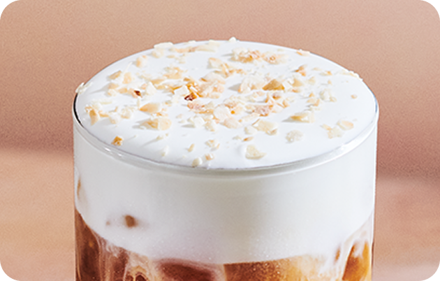 The top of a cold drink finished with cold foam and Toasted Coconut Topping.