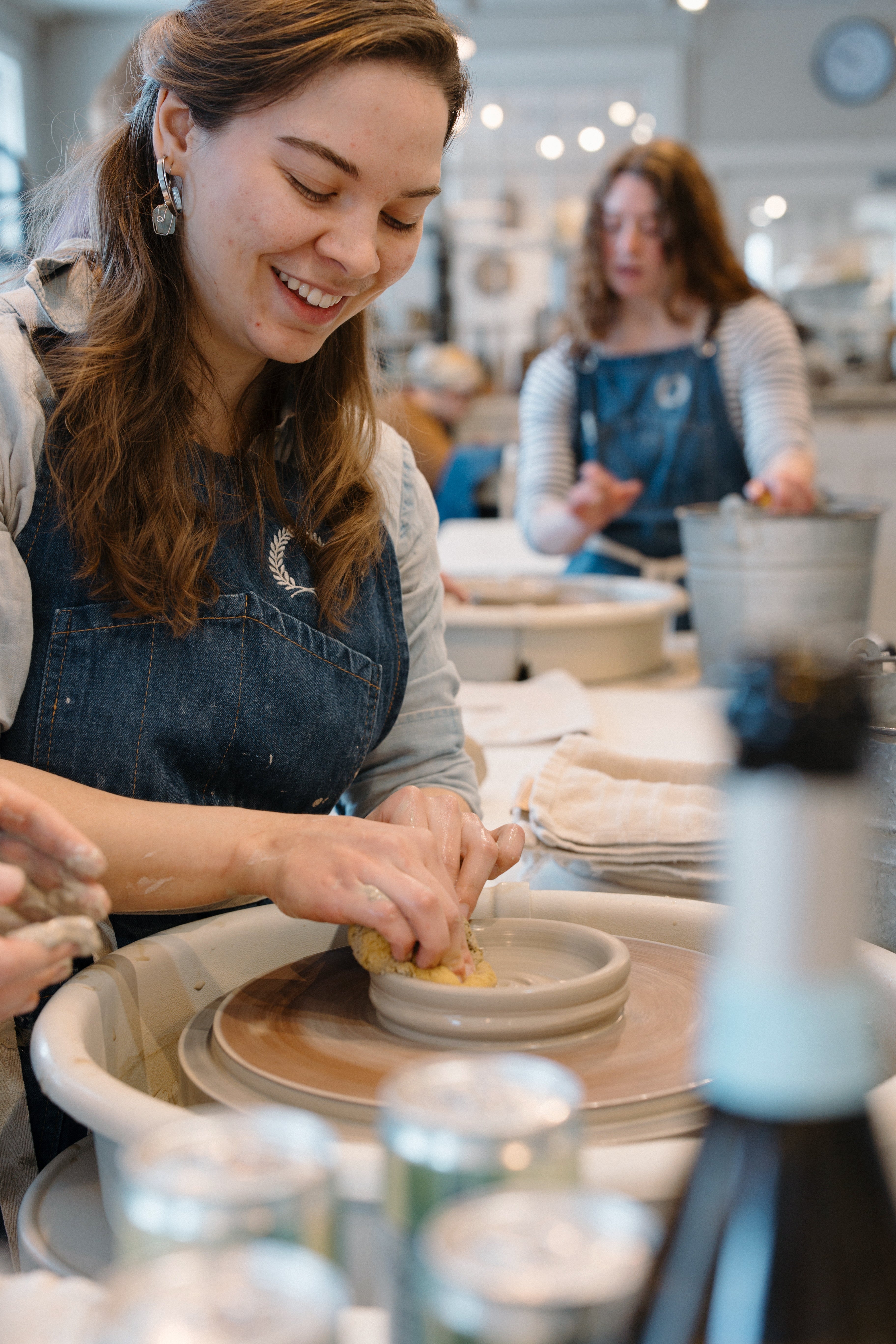 A guest at the wheel during a Farmhouse Pottery workshop