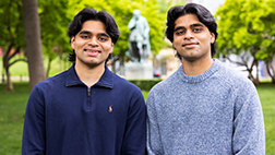 Daivik and Shrenik Patel standing in front of the William the Silent statue on the College Ave campus