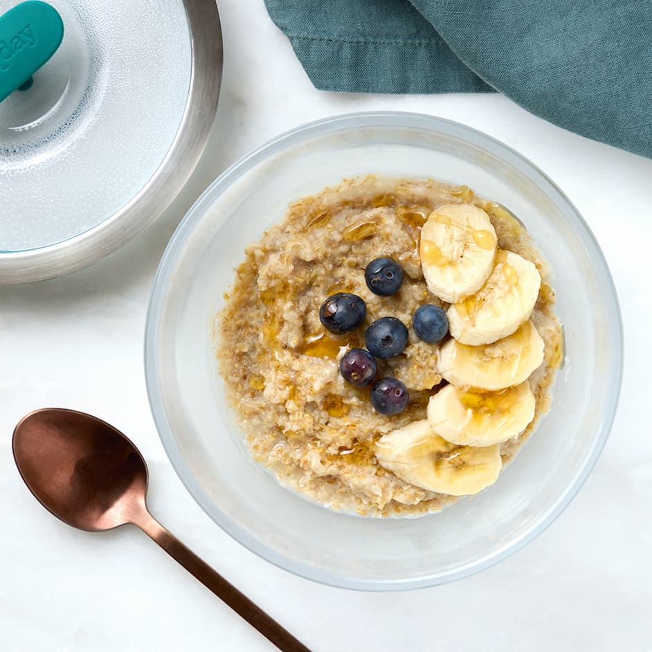 A 4-cup deep dish of oatmeal with blueberries and banana slices on top