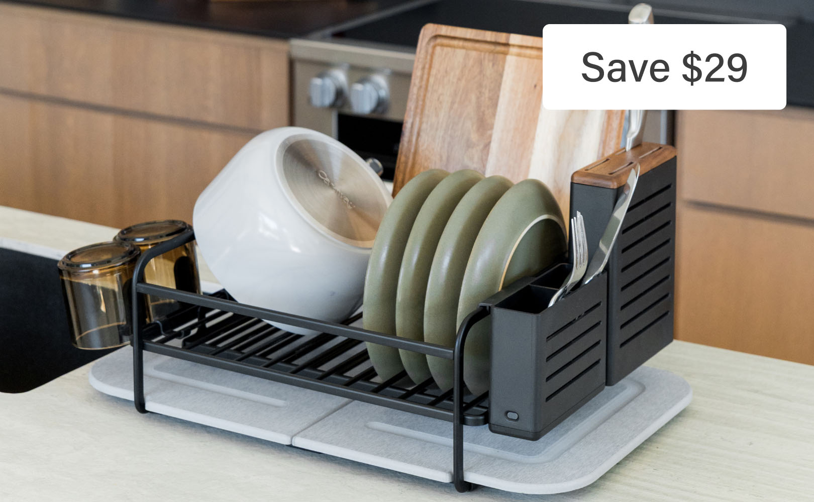Dish rack with plates and cutlery on counter.