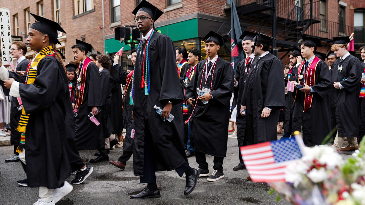 Caption : Graduates walk onto the Harvard campus for the university's 374th commencement.