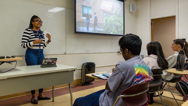 student presents about Campus Pantry at front of classroom