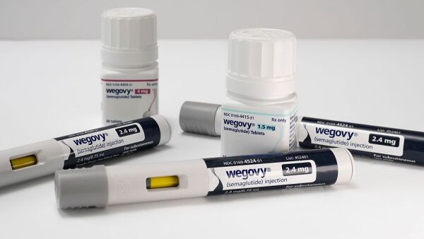 Wegovy 1.5 mg and 4 mg semaglutide tablets with injectable prescription weight loss pens on a white background.