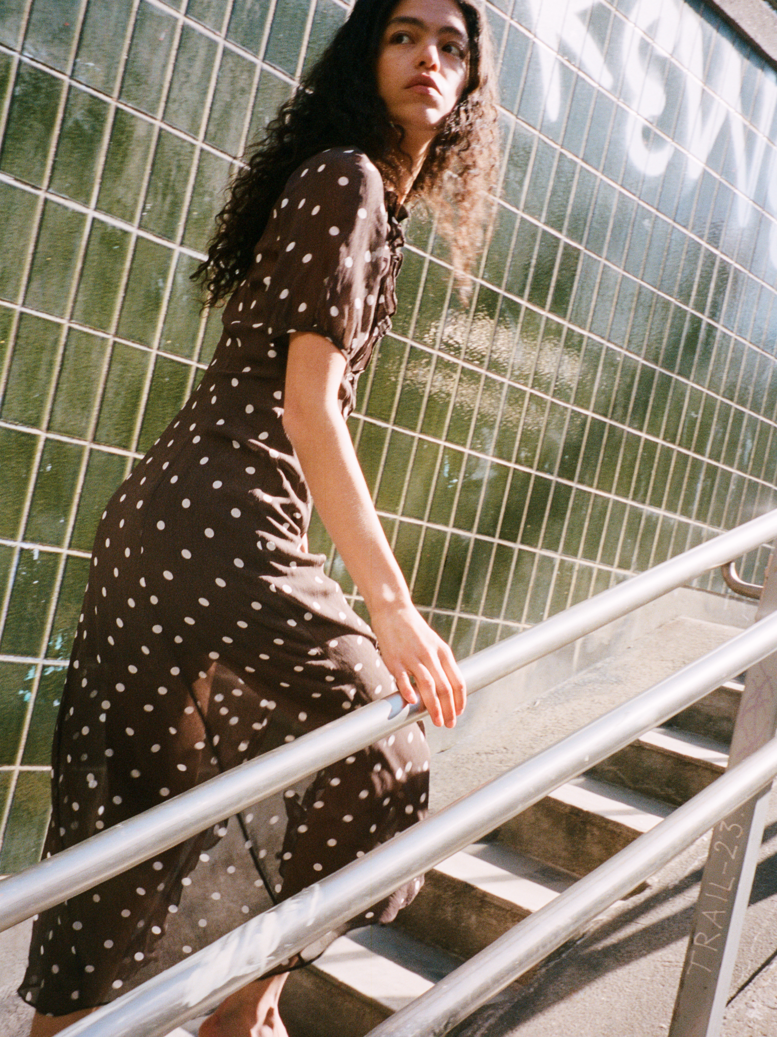 Girl in brown polka dot shirt and striped denim jeans