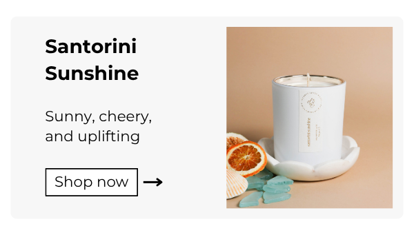 fresh and clean candle santorini sunshine styled with citrus slices and aqua milk glass, product name and description