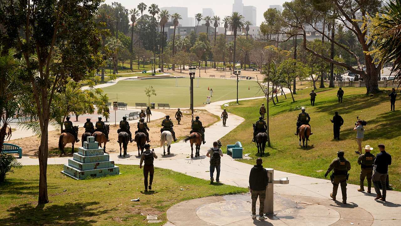 Federal agents ride on horseback at MacArthur Park in Los Angeles