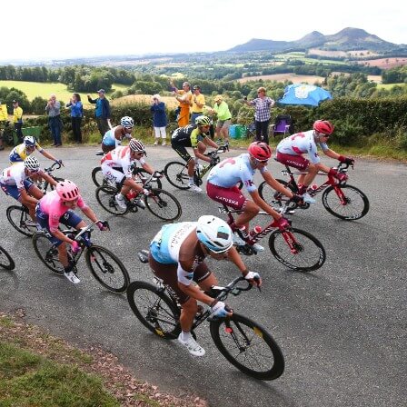 Cyclists coming round a corner on a hill