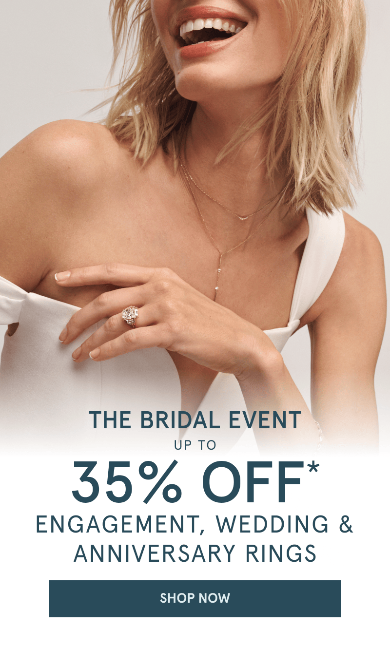 A model wearing a diamond ring and two dainty gold diamond necklaces.