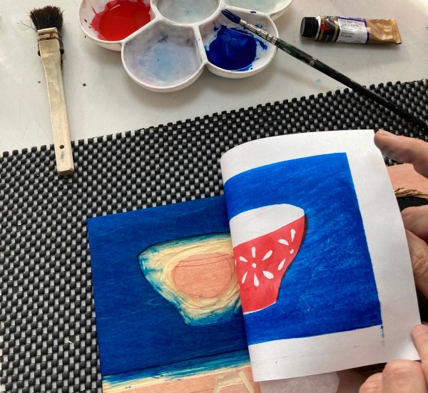 Revealing a blue and red woodblock print by removing the paper from the woodblock.