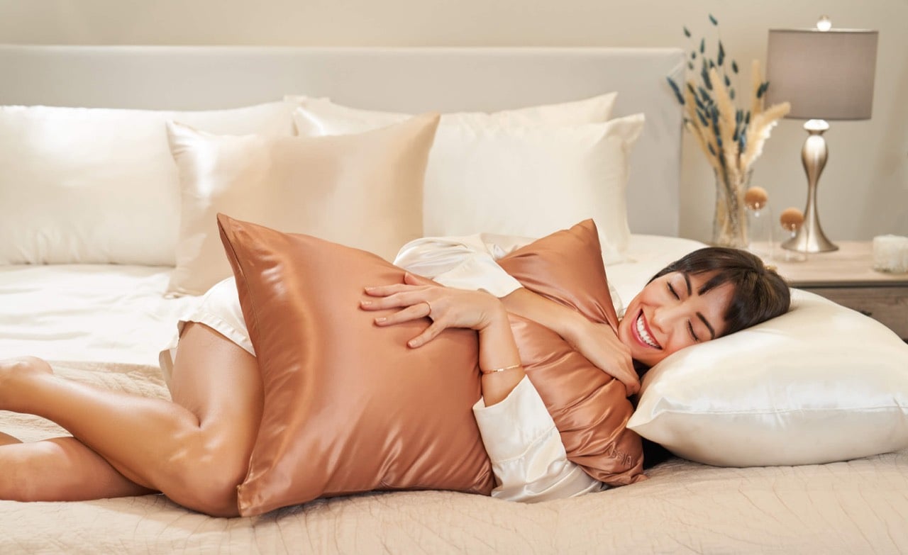 A woman resting happily on a Blissy mulberry silk pillowcase