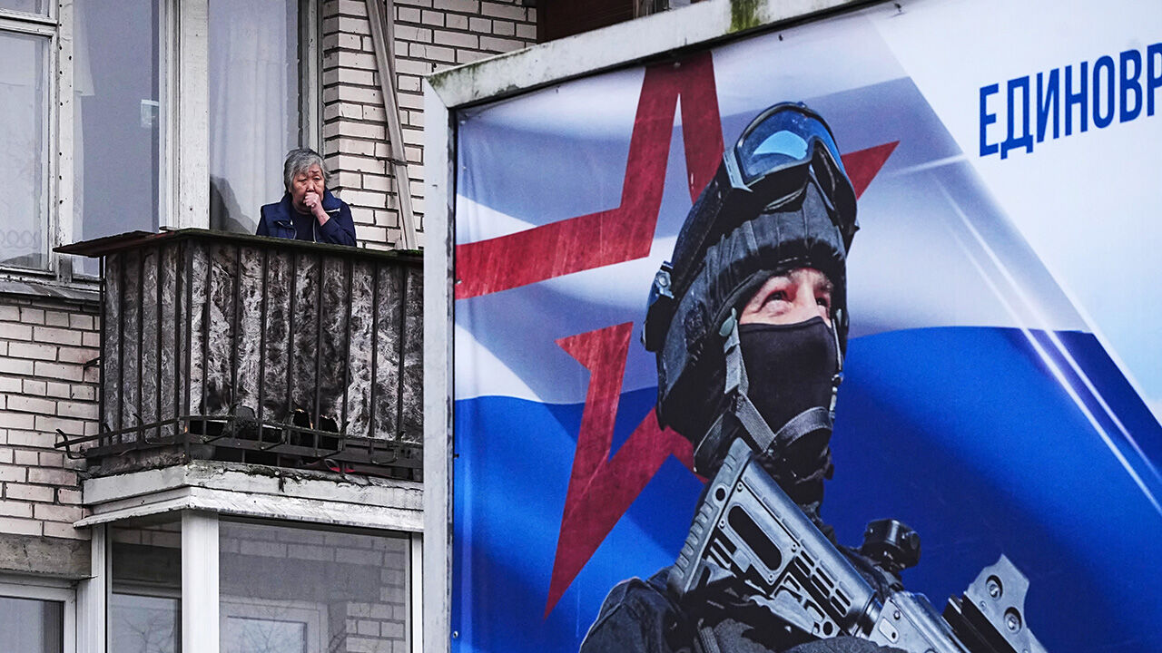A woman stands on a balcony of an apartment building in St. Petersburg, Russia.