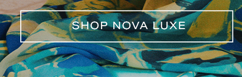 Luxurious fabric with abstract teal, blue, and yellow pattern, folded artfully. Shop Nova Luxe for new apparel and stylish textiles.