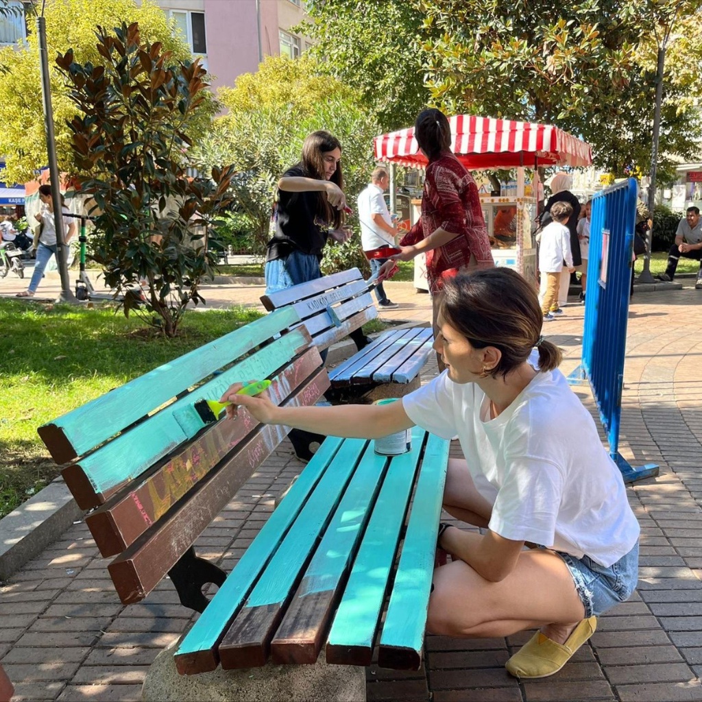 A woman painting a bench