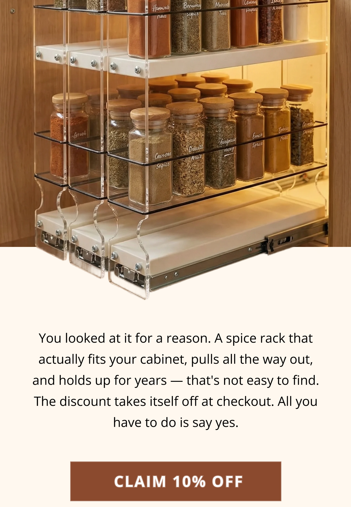 Fully extended spice rack drawer with labeled glass jars, designed to maximize cabinet space and keep spices organized
