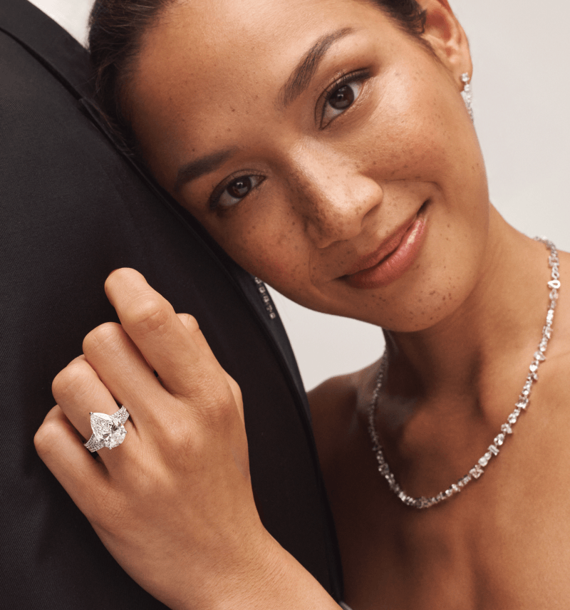 A model wearing a ring with a pear shaped diamond in the centre.