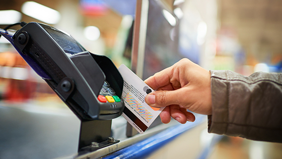 A person swipes a credit card.