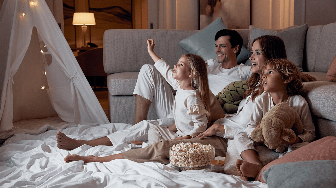A family enjoying movie night with popcorn in a residence.