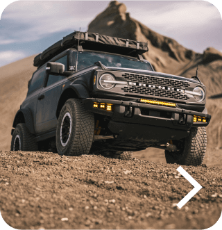 A Bronco&reg; SUV with Sasquatch&reg; Package being driven off‑road in a desert landscape