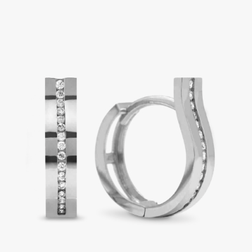 A pair of white gold huggie hoop earrings on a gray tile.