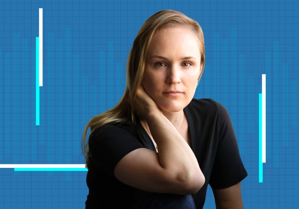 Kate Wassum in a black shirt against a blue grid background