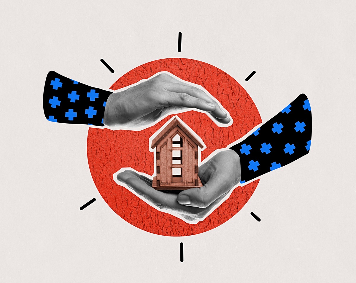 One hand holding a house, the other hand over the top of it