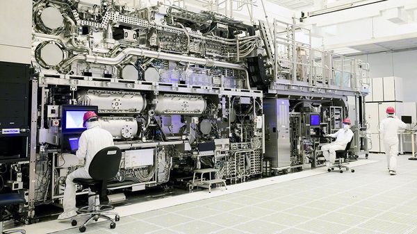 Workers are seen in front of a High NA EUV lithography system at an Intel facility in Hillsboro, Oregon, U.S.