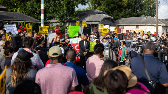 Protesters hold signs at a vigil.
