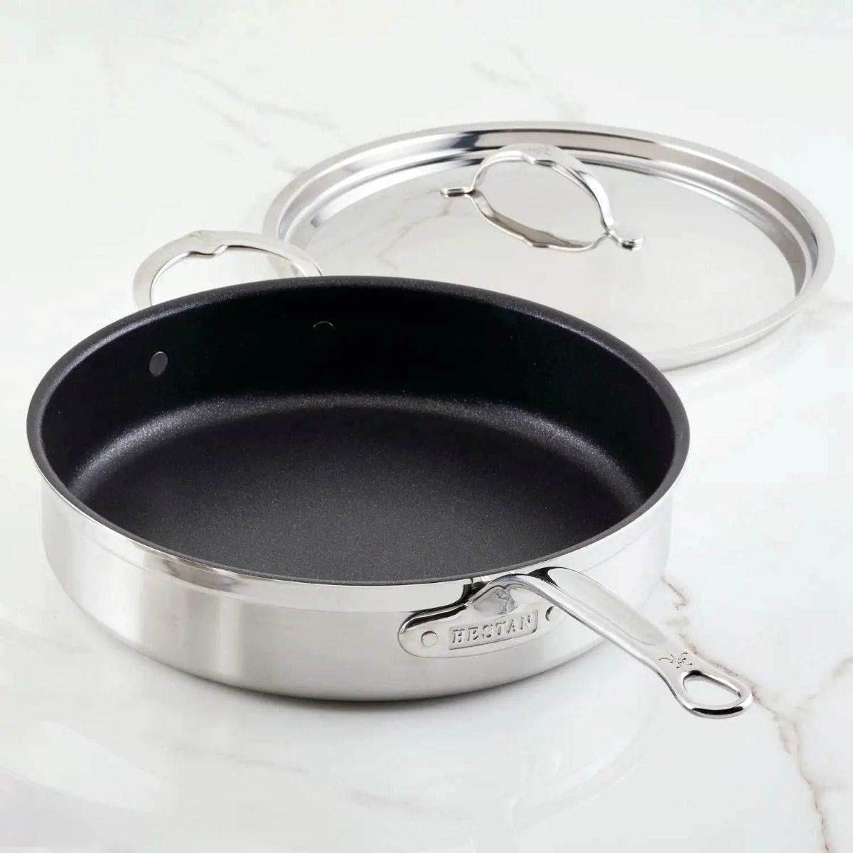 IMG: Brushed Clad Stainless Steel TITUM® Nonstick Sauté Pan with Lid, 5-Quart on marble countertop