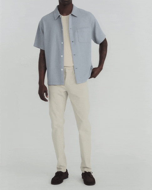b'The model is wearing LHomme Slim Brushed Twill in Milk Beige'