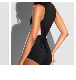 Black swimsuit with a pink side and a tied back detail.