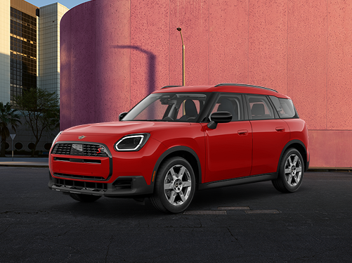 A MINI Countryman SE parked in front of an orange wall.