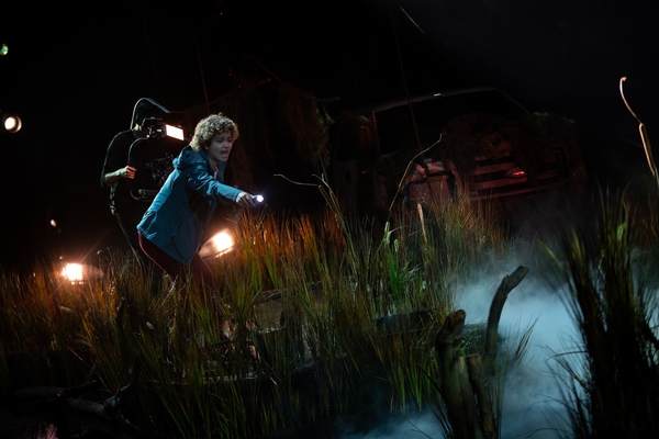 A woman searches a swamp in a stage production