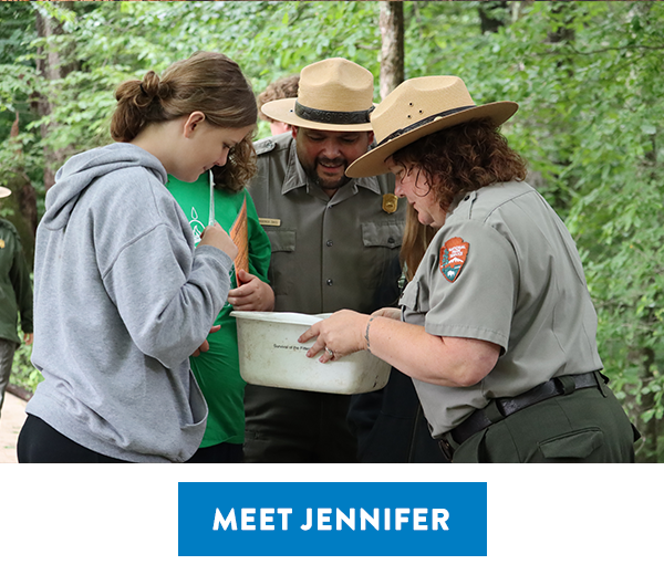 Park Ranger Jennifer Shackelford works at Mammoth Cave National Park, holding a box for students and a fellow ranger to peer into