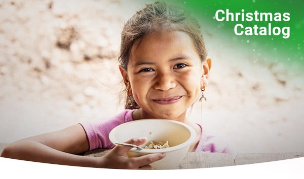 A girl smiles as she eats nutritious Vitafood.