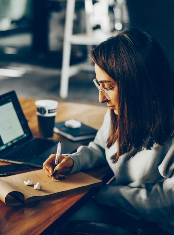 Student sitting at a table writing notes