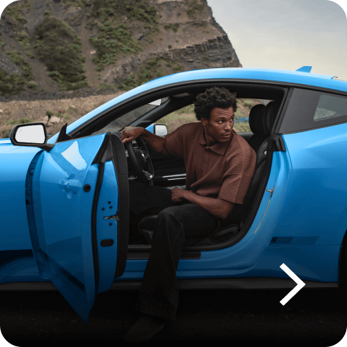 A man exiting a blue Ford Mustang® EcoBoost® Fastback model