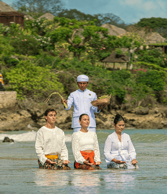 People participating in a traditional water blessing ceremony by the sea.