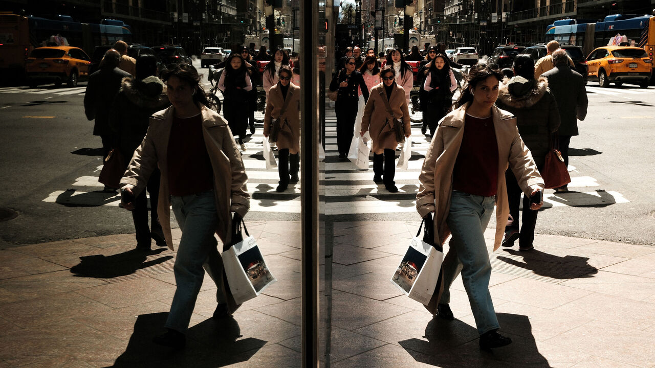 Pedestrians and cars reflected in the window of a building in Manhattan.  