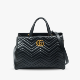 A Gucci GG Marmont Tote in black matelassé leather on a gray tile.