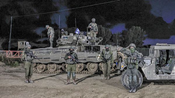 Israeli soldiers stand in a moment of silence near the Israeli border with the Gaza Strip 