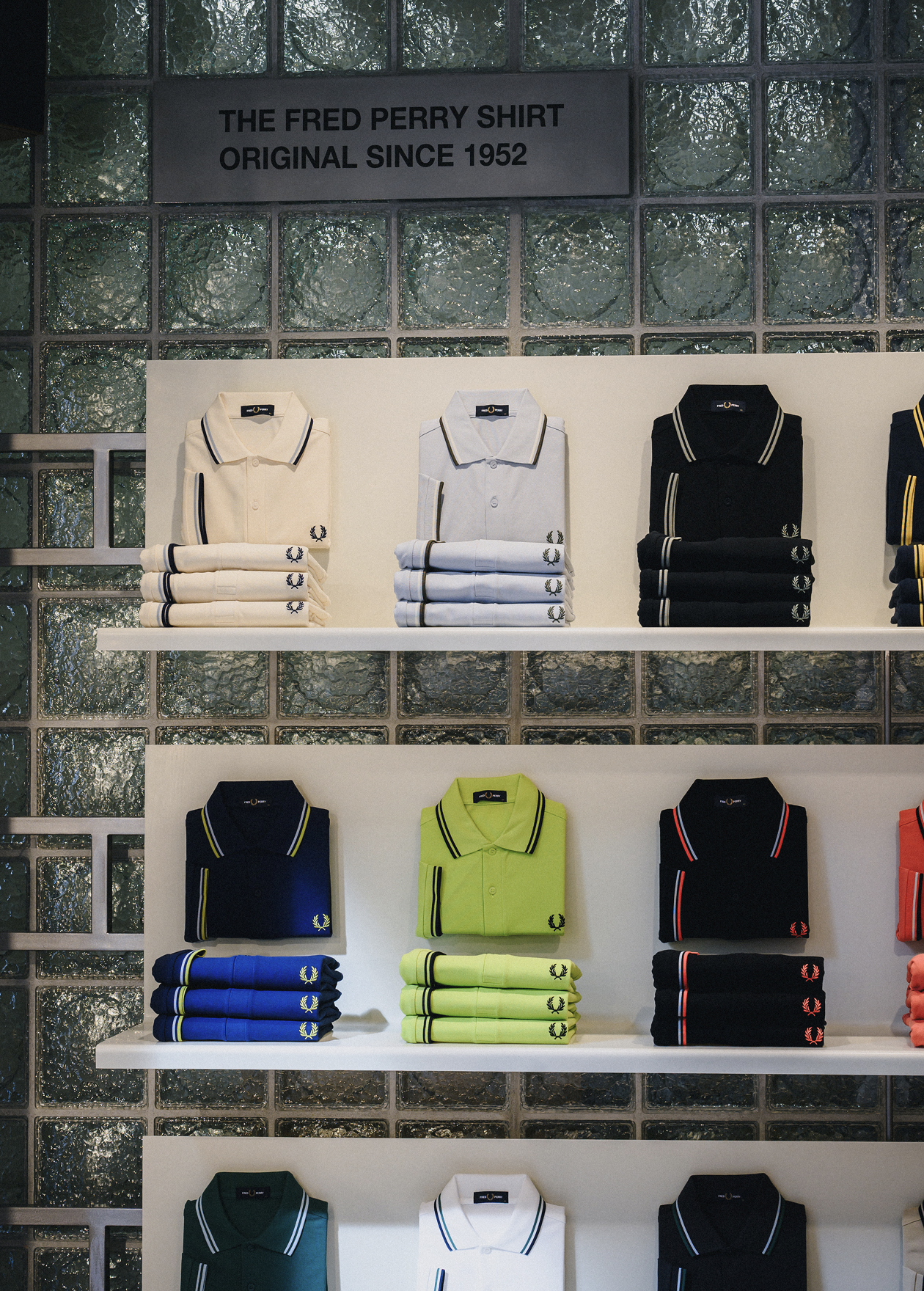 Vibrantly coloured Fred Perry polo shirts being displayed on the wall of our London Soho store