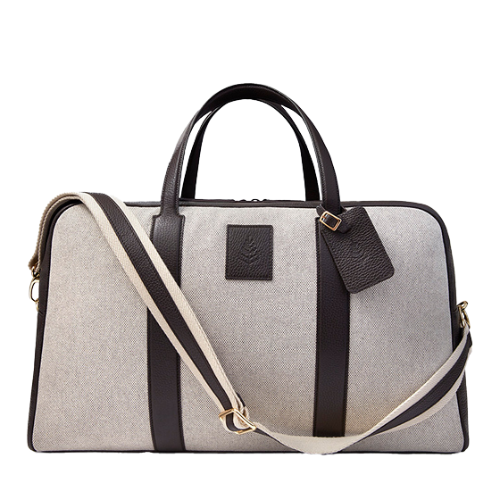 Luxurious canvas travel bag with leather detailing, straps, and handles.