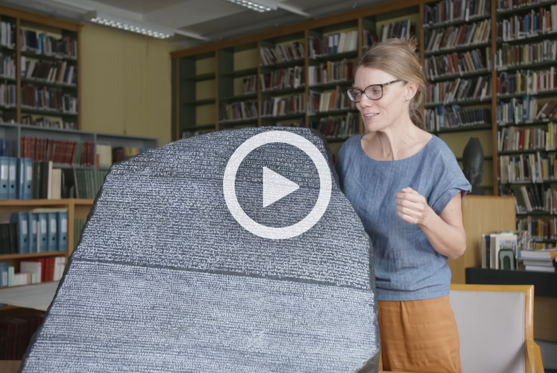 Curator stood next to replica of Rosetta Stone.