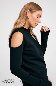 Side profile of Maritza wearing The William Cutout Sweatshirt with ribbed cuffs and neckline.