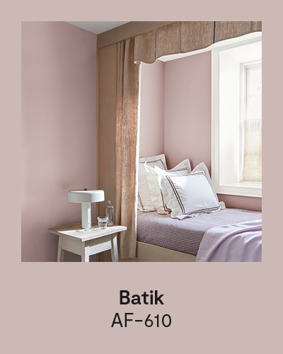 Batik AF-610 - A pink painted bedroom features a built-in bed with purple linens and frilly pillows.
