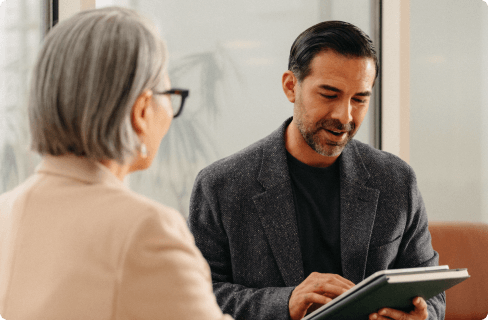 Photo-of-two-coworkers-talking-over-tablet-in-office