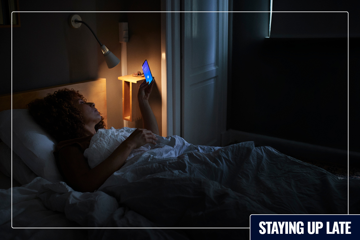 A person looks at a phone in bed.