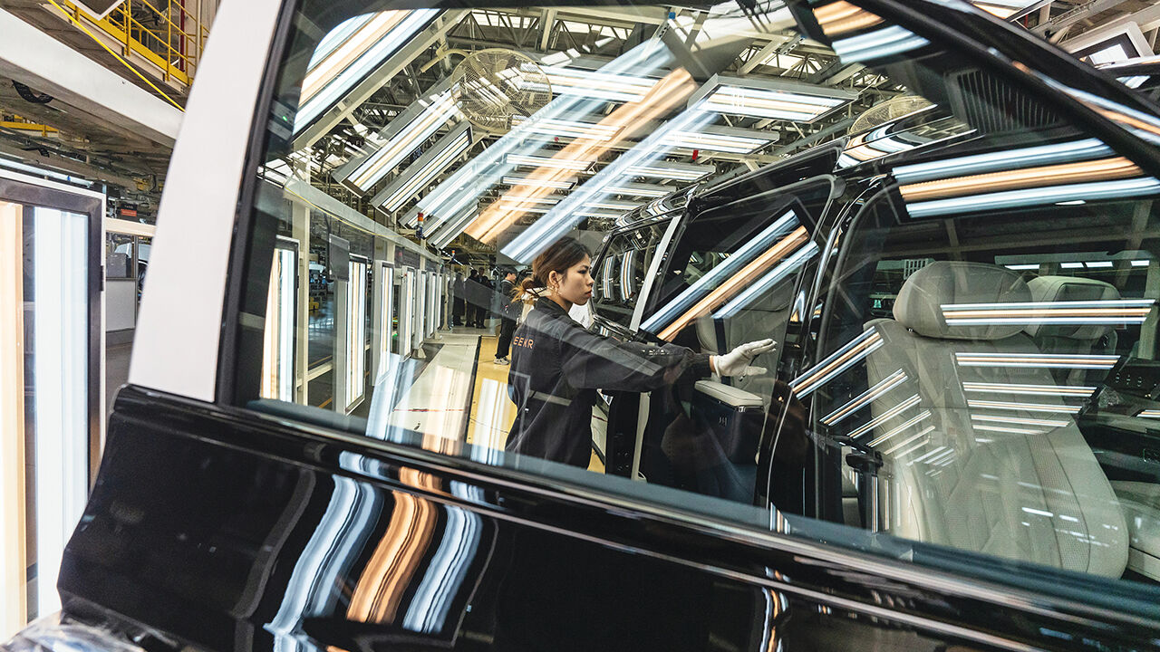 A worker with white gloves inspects a vehicle on the assembly line at a factory of the electric carmaker Zeekr in Ningbo, China.