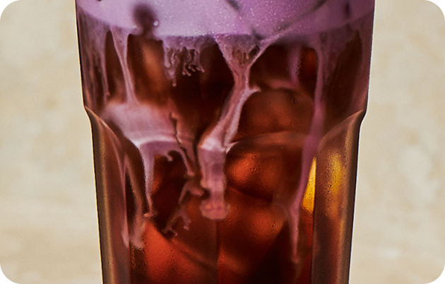 Raspberry syrup cascading into a cold brew.